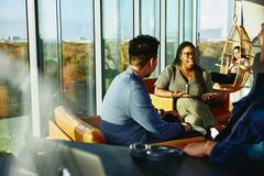 Två personer har en konversation sittandes i en lounge miljö