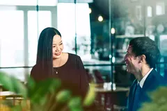 male and female talking and smiling.
