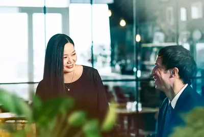 male and female talking and smiling.

