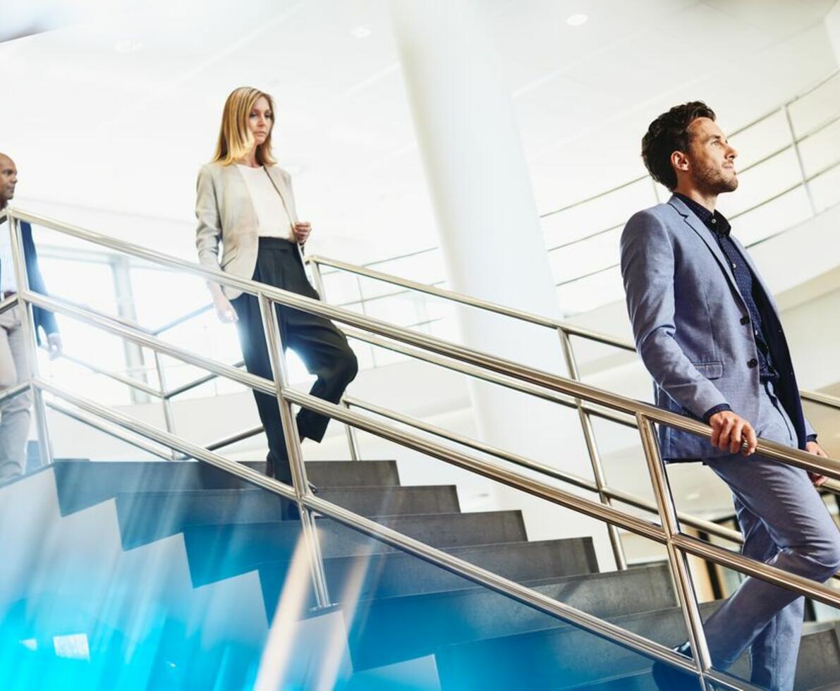 three colleagues descend from the stairs in the office