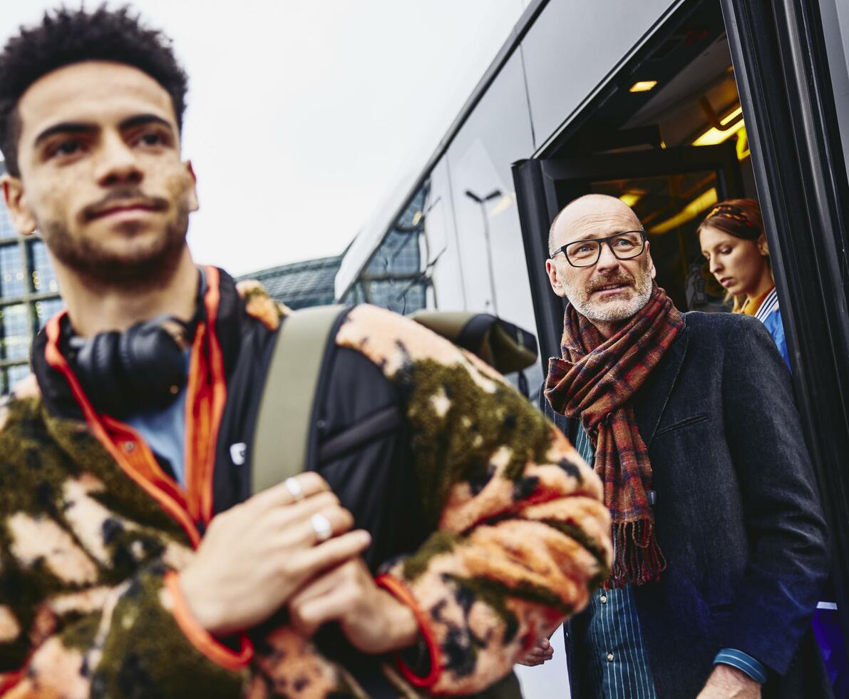 flera personer går av en buss