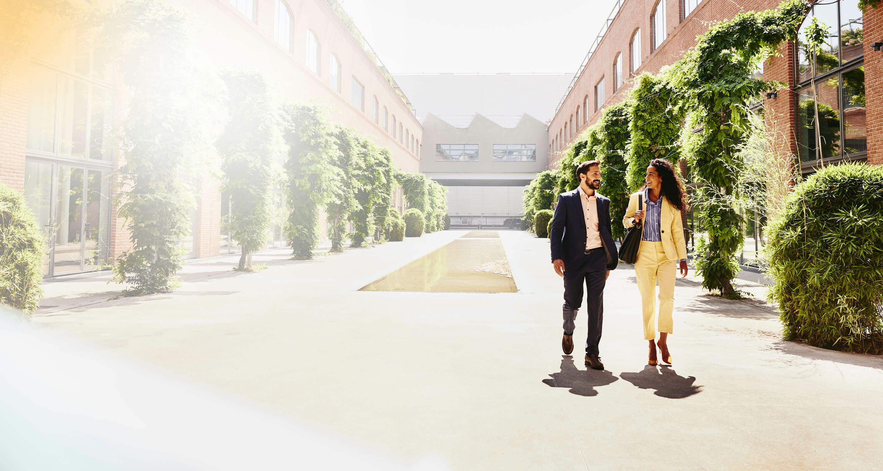 man and woman walking outside between office buildings