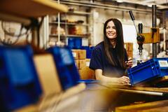 leende kvinna som jobbar i produktionen