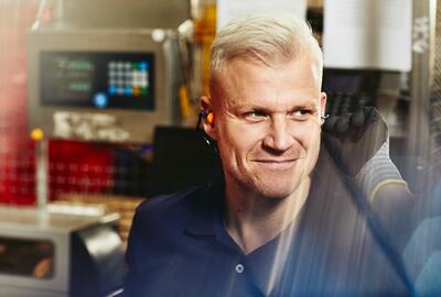 leende man som bär skyddshandskar och hörselskydd