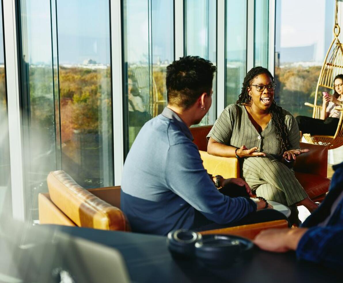 Två personer har en konversation sittandes i en lounge miljö