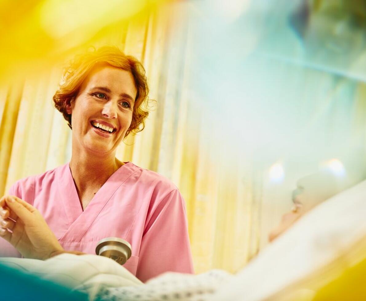 kvinna i sjukhus kläder tittar snett ner på sin patient