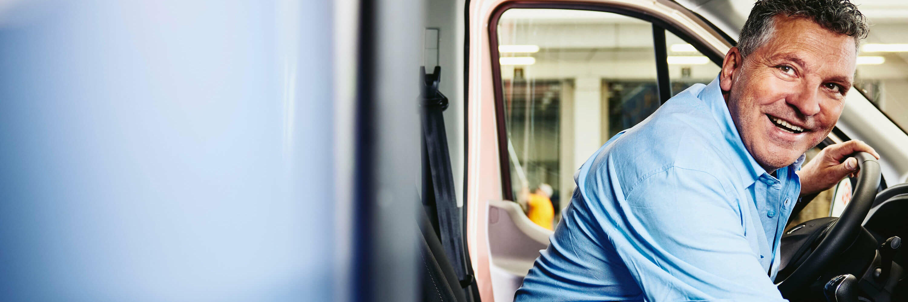 leende man sitter i förarsätet på en lastbil