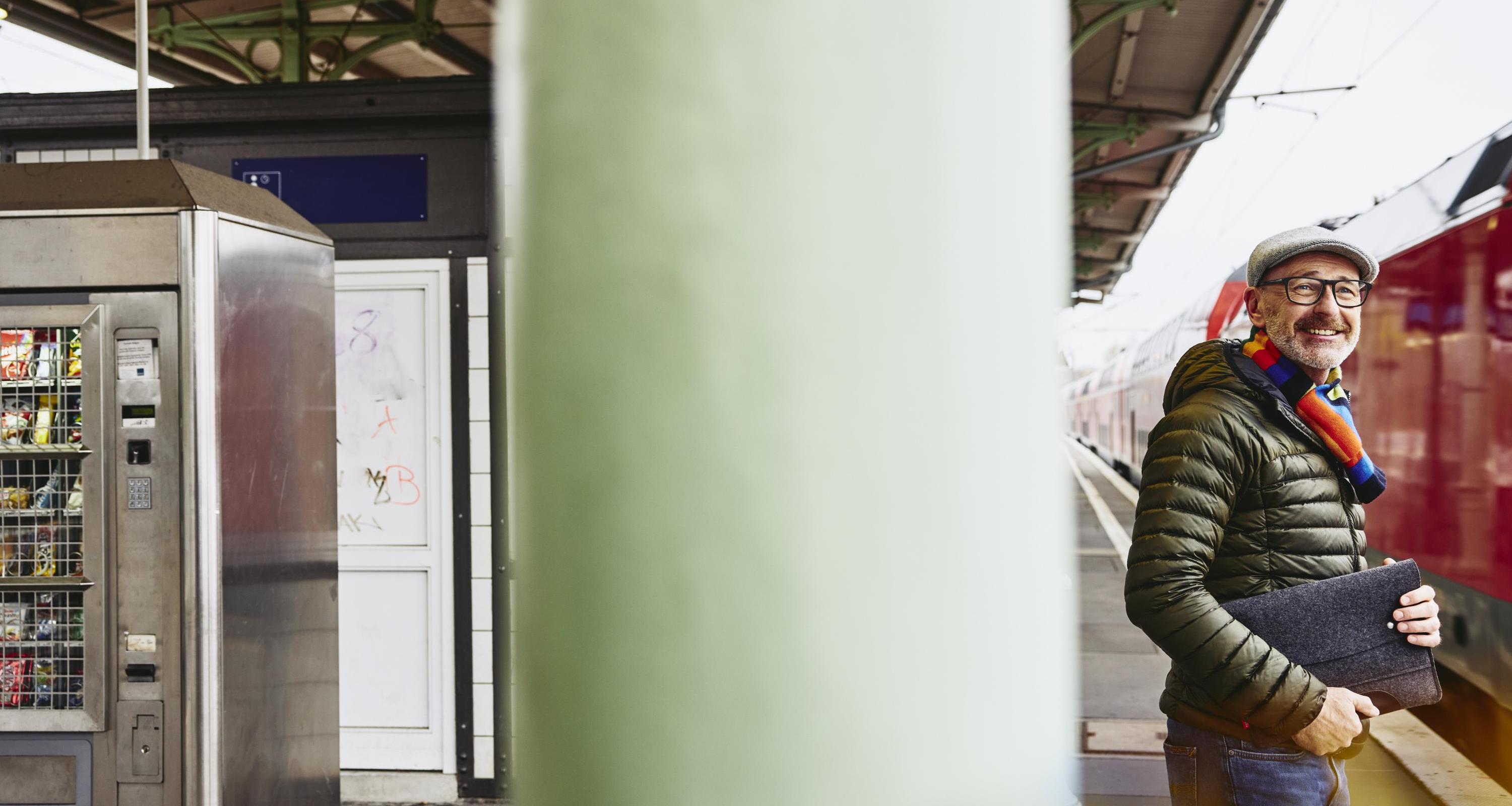 en man står på perrongen och väntar på sitt tåg